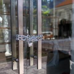 Closed glass door with metal chain and lock around handles