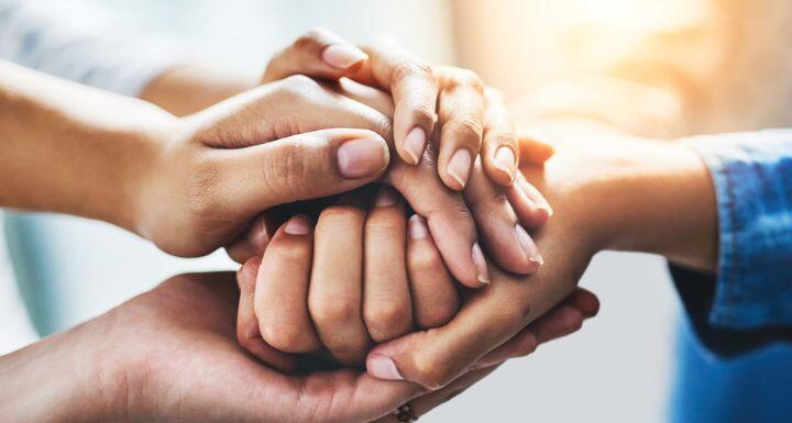 Closeup shot of a group of unrecognizable people joining their hands together
