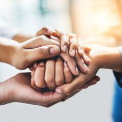 Closeup shot of a group of unrecognizable people joining their hands together