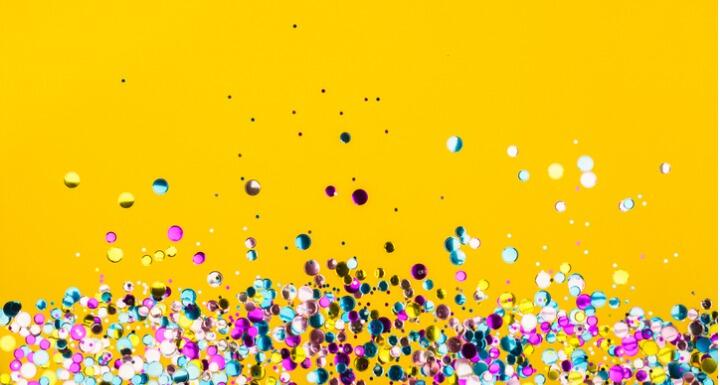 Colorful confetti on yellow background