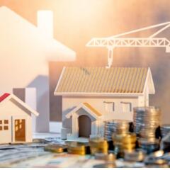 Construction of house with money in foreground