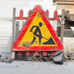 A  large construction caution sign for drivers prominently displayed on a construction site