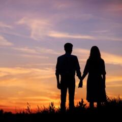 Couple holding hands at sunset