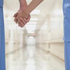 two people in medical scrubs holding hands