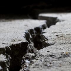 Concrete ground with large crack in running through it