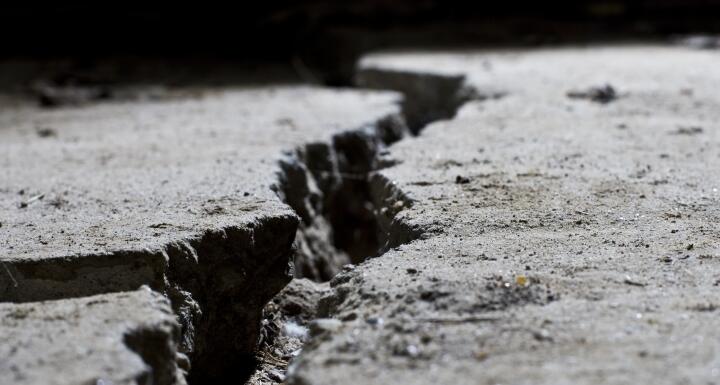 Concrete ground with large crack in running through it