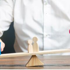 Wooden Parents on the opposite ends of a seesaw with kids in middle