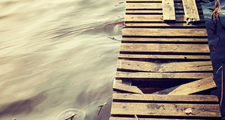 Pier over water with damaged boards