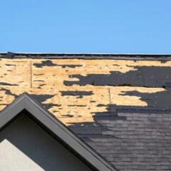 Damaged house roof with missing shingles