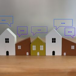 Different colored wooden toy houses with speech bubbles