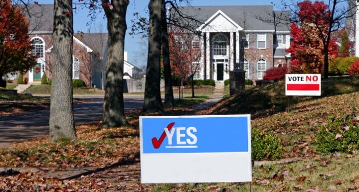 A landscape showing political signs in neighborhood yards