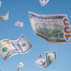 100 dollar bills falling from blue sky