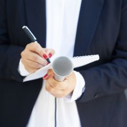 Female journalist at news conference or media event-Color Icon