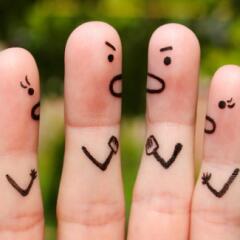 Four fingers with angry faces and arms drawn on them with two fingers looking at the other two and they look like they are fighting with each other