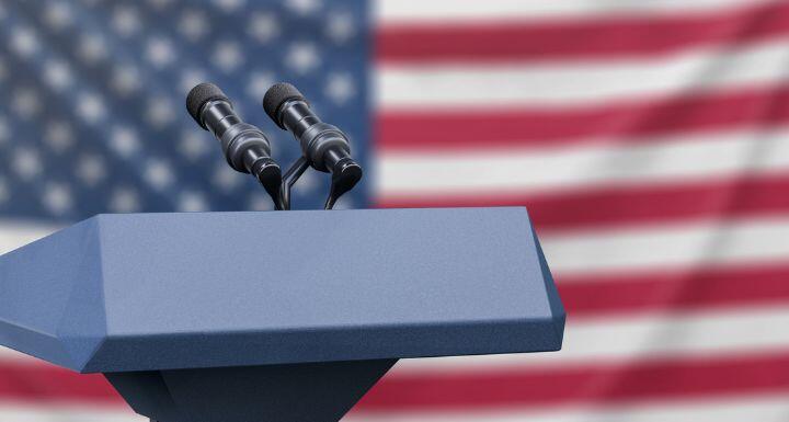 Flag of the United States at a press conference with microphones