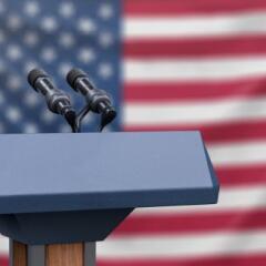 Flag of the United States at a press conference with microphones