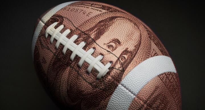 Football with $100 superimposed on its skin