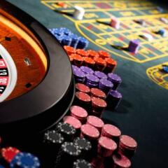 Gambling chips stacked around roulette wheel on gaming table
