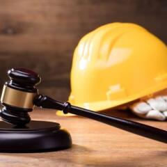 Gavel In Front Of Yellow Safety Helmet