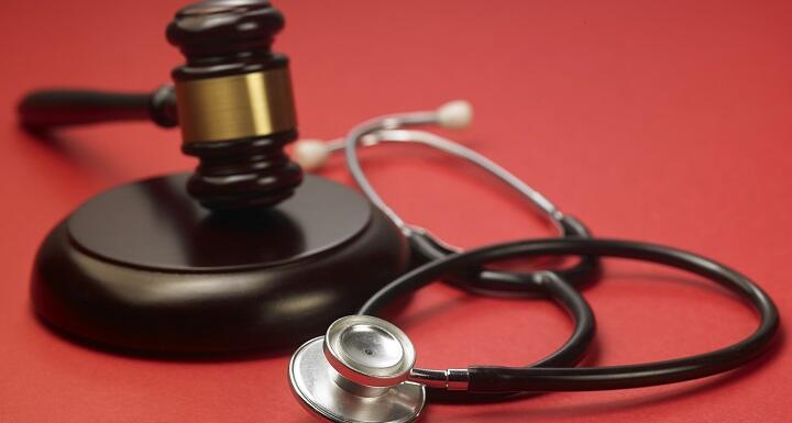 A gavel and a stethoscope sitting on a red background signifying an investigation by the North Carolina Medical Board