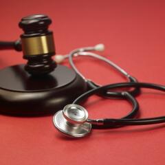 A gavel and a stethoscope sitting on a red background signifying an investigation by the North Carolina Medical Board