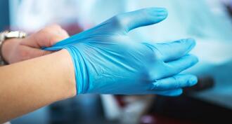 Blue medical gloves in hands at a medical office
