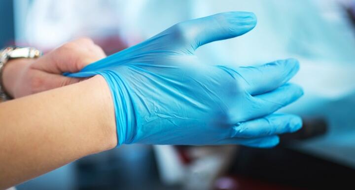 Blue medical gloves in hands at a medical office