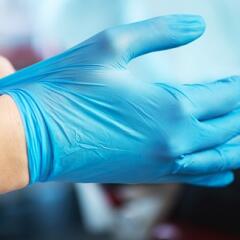 Blue medical gloves in hands at a medical office