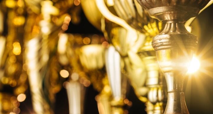 Row of gold trophies standing side by side