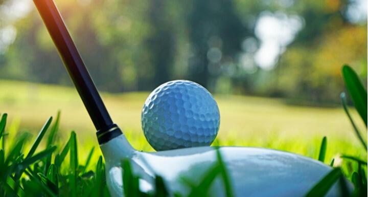 Golf ball and club at sunset