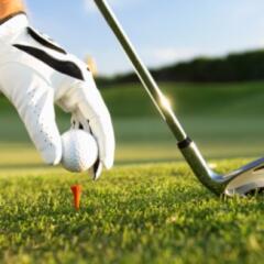 Golfer putting ball on Tee