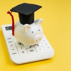 Illustration of a piggy bank wearing a graduation cap and tassel on top of a calculator