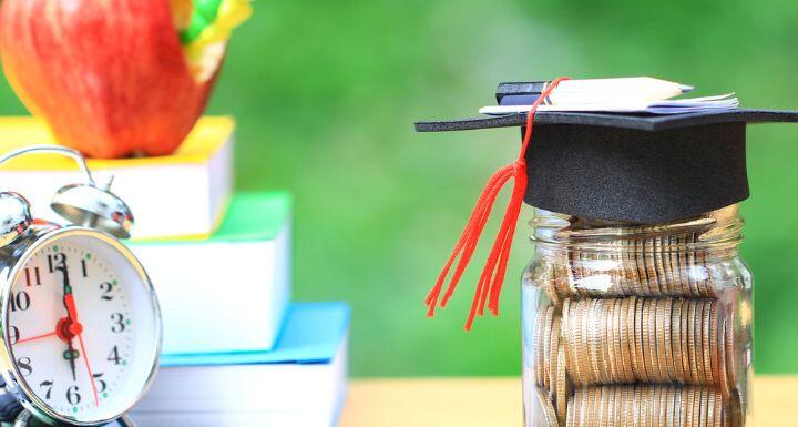 Graduation hat on the glass bottle and books on natural green background