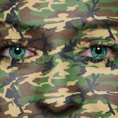 A face covered with green camouflage facepaint