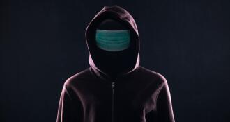 Hooden man wearing a medical mask