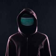 Hooden man wearing a medical mask