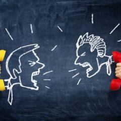 Hand holding vintage telephone receiver over chalkboard background