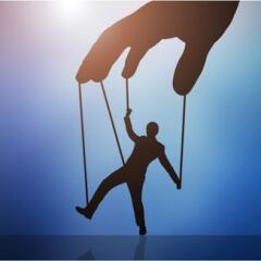 hand manipulating businessman attached to stings