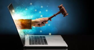 Hand with hammer coming out of a laptop