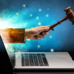 Hand with hammer coming out of a laptop 