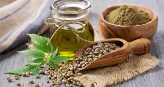 Hemp oil, seeds, and leaves arranged on a countertop