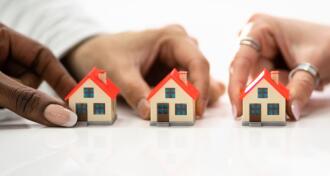 People Holding House Model On White Surface