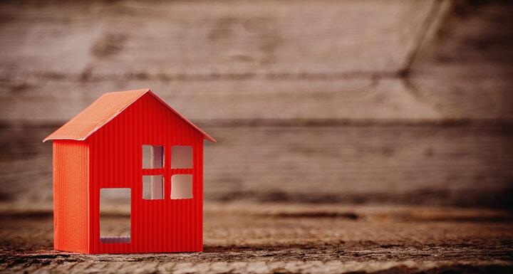 Orange 3D Paper House on wooden background