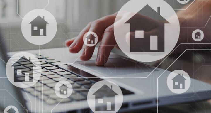 Houses in bubbles floating over laptop keyboard