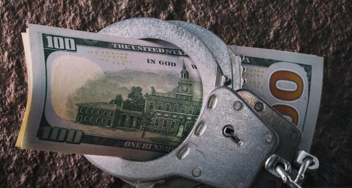 Hundred dollar bills in handcuffs
