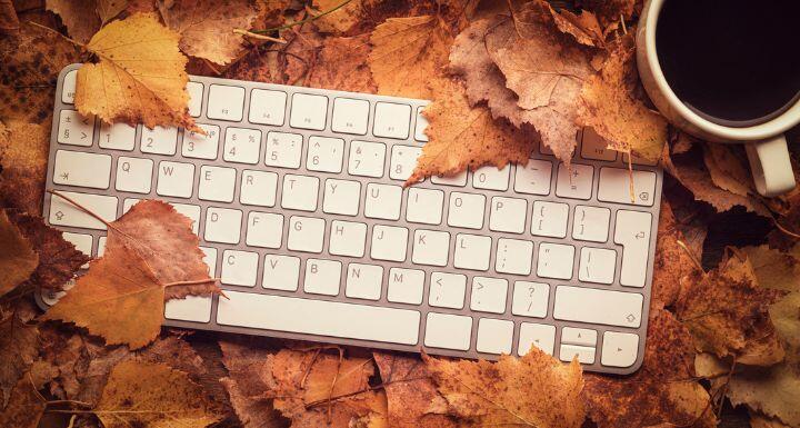 Keyboard, cup of coffee on leaves