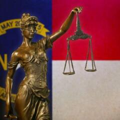 Lady Justice before a flag of North Carolina