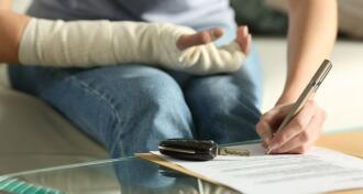 Lady with broken arm signing insurance document after car accident