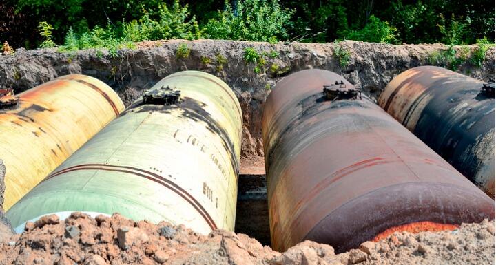 Large metal tanks are buried in the ground