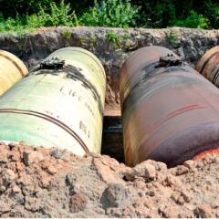 Large metal tanks are buried in the ground